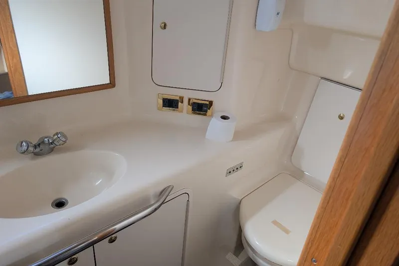 Slide: The Image of Bathroom interior of 2000 Sea Ray 420 Aft Cabin yacht, featuring sink and toilet. - 14