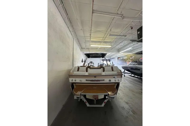 Slide: The Image of 2026 Malibu Wakesetter 24 MXZ boat in showroom, rear view. - 2
