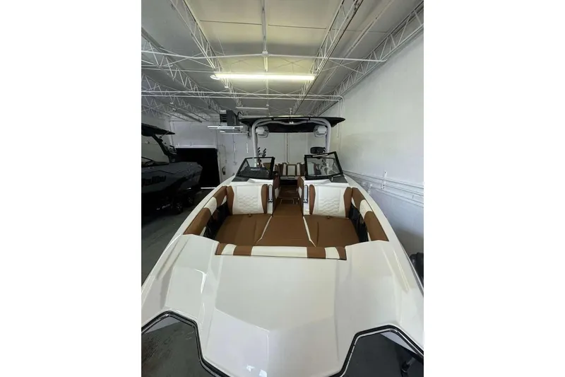 Slide: The Image of 2026 Malibu Wakesetter 24 MXZ boat interior with brown and white seating. - 6