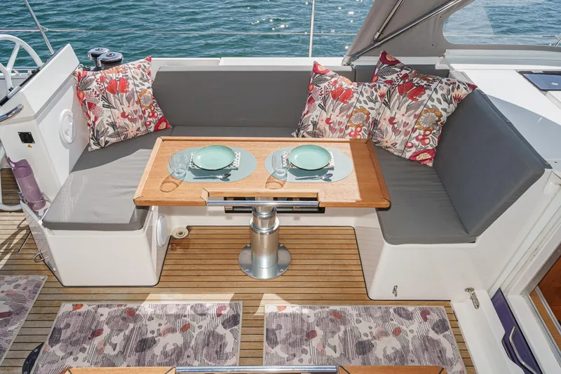 Slide: The Image of Cozy seating area on 2023 Bavaria C50 yacht with floral cushions and dining setup. - 16