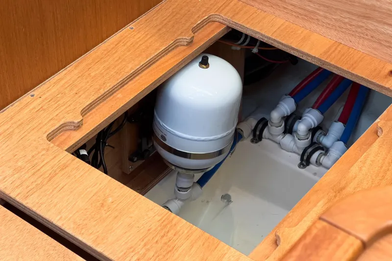 Slide: The Image of 2023 Bavaria C50 yacht plumbing system with wooden paneling and water connections. - 59