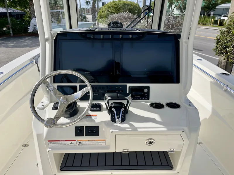 Slide: The Image of Cobia 285 Open Center Console 2026 helm with steering wheel and screens. - 11