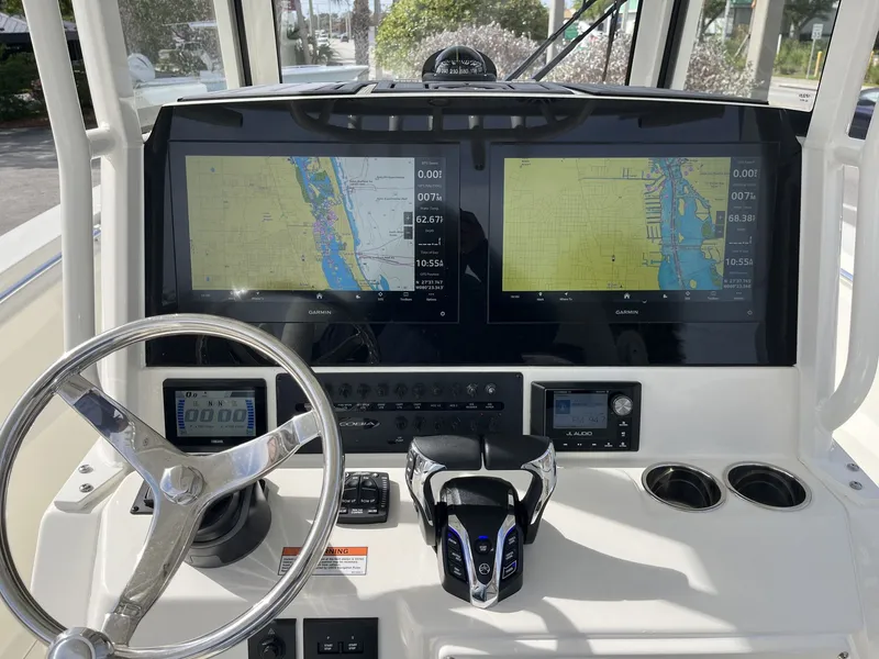 Slide: The Image of 2026 Cobia 285 Open Center Console dashboard with Garmin displays. - 12