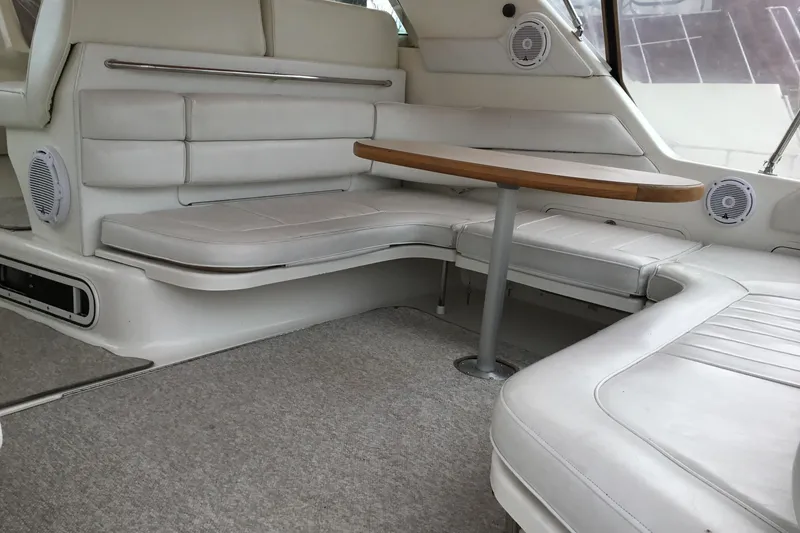 Slide: The Image of Interior of a 1995 Sea Ray Sundancer 370 with white seating and a wooden table. - 10