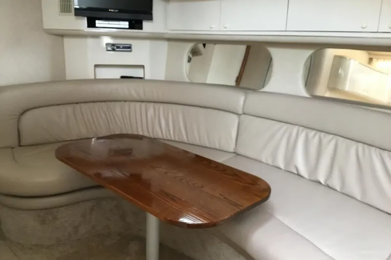 Slide: The Image of Interior of 1995 Sea Ray Sundancer 370 with beige seating and wooden table. - 13