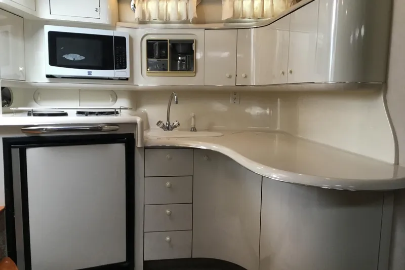 Slide: The Image of 1995 Sea Ray Sundancer 370 yacht kitchen with microwave, sink, and storage cabinets. - 15
