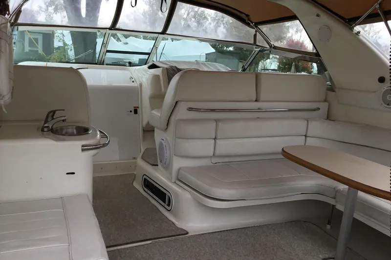 Slide: The Image of Interior of 1995 Sea Ray Sundancer 370 yacht with white seating and compact kitchenette. - 7