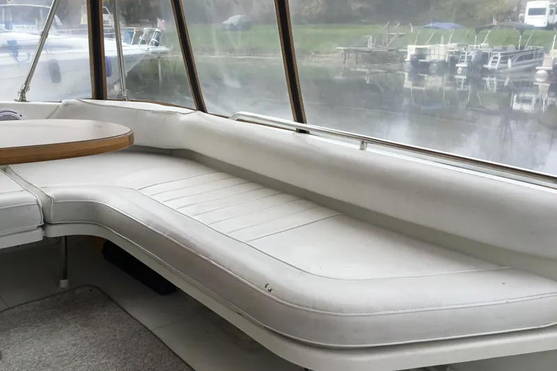 Slide: The Image of Interior view of a 1995 Sea Ray Sundancer 370 with white seating and a round table. - 9