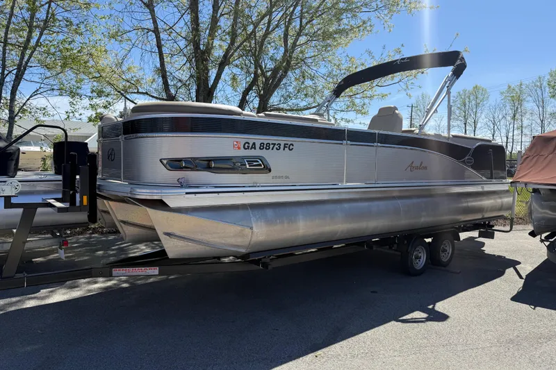 The Image of 2020 Avalon Catalina Quad Lounge 25' pontoon boat on trailer, parked outdoors. - 0