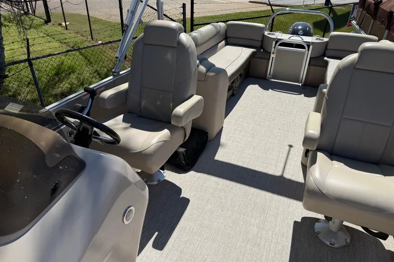 Slide: The Image of 2020 Avalon Catalina Quad Lounge boat interior with beige seating and steering console. - 6