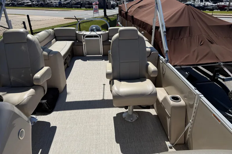 Slide: The Image of 2020 Avalon Catalina Quad Lounge 25' pontoon boat interior with beige seating and helm. - 8