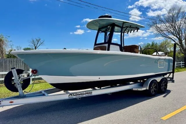 The Image of 2022 Sea Hunt Ultra 255 SE boat on trailer, parked on a sunny road. - 1