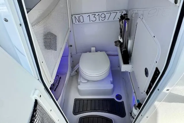 Slide: The Image of 2022 Sea Hunt Ultra 255 SE boat interior with compact marine toilet and storage. - 13