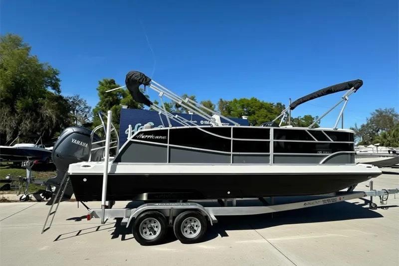 The Image of 2026 Sweetwater FD2260RE3 pontoon boat on trailer, sunny day, Yamaha engine visible. - 1