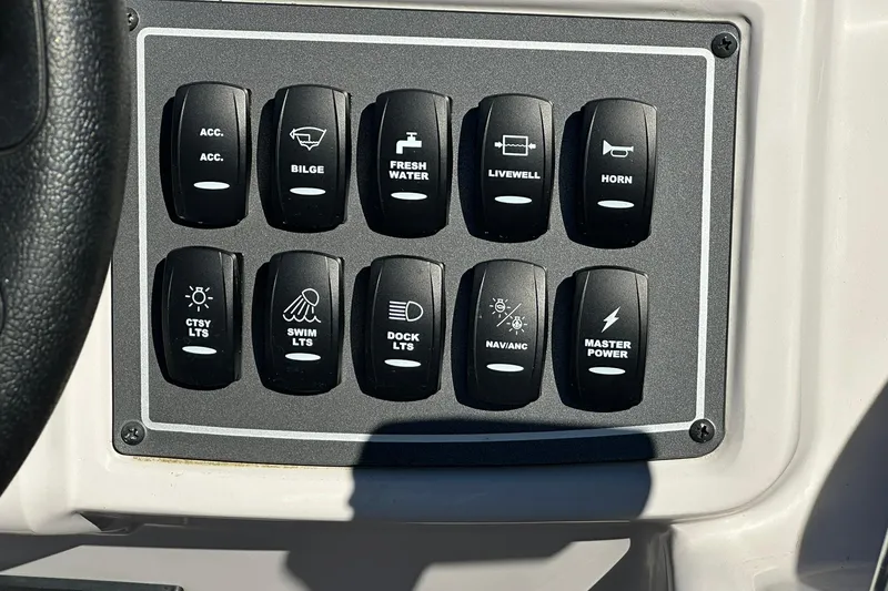 Slide: The Image of Control panel of 2026 Sweetwater FD2260RE3 boat with labeled switches. - 17