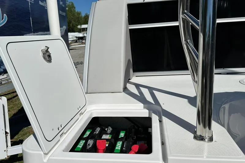 Slide: The Image of Open battery compartment on 2026 Sweetwater FD2260RE3 boat, showcasing marine batteries. - 27