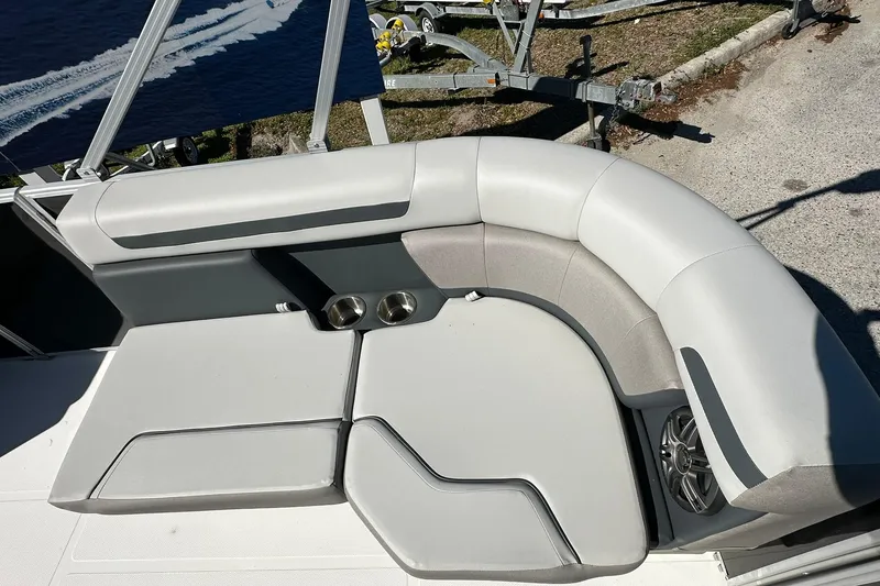 Slide: The Image of 2026 Sweetwater FD2260RE3 boat interior with cushioned seating and cup holders. - 7