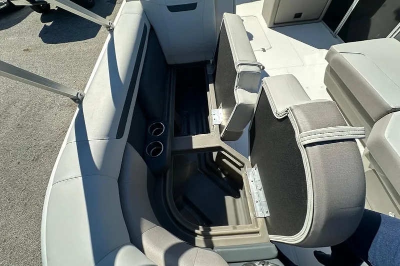 Slide: The Image of 2026 Sweetwater FD2260RE3 boat interior with open storage and cup holders. - 9