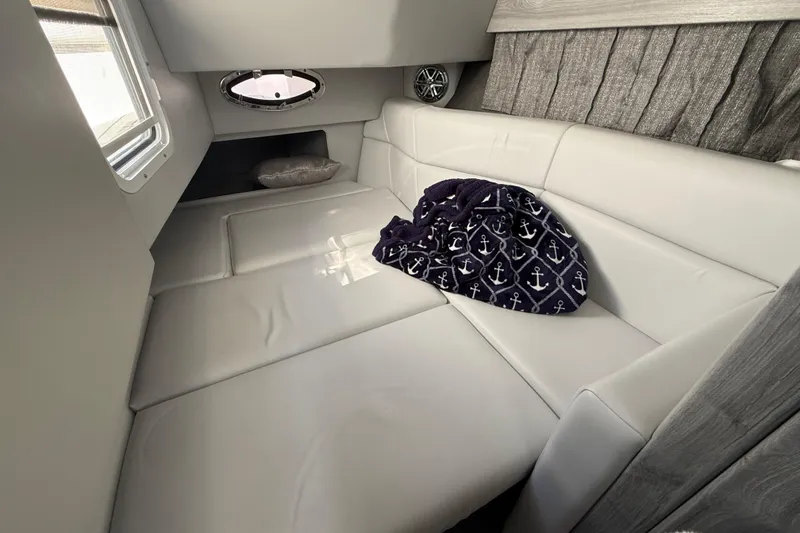 Slide: The Image of 2021 Formula 330 Crossover Bowrider OB cabin with plush seating and nautical-themed blanket. - 35