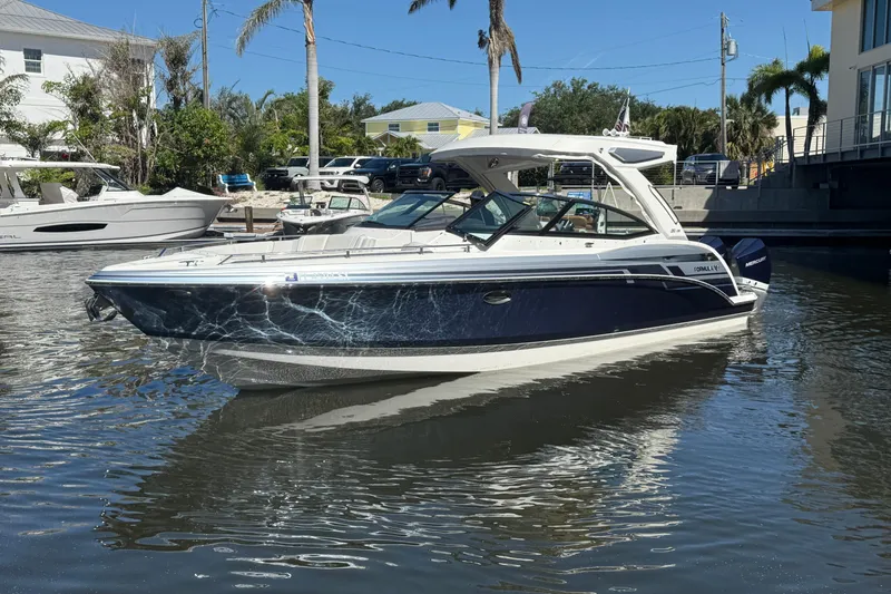 Slide: The Image of 2021 Formula 330 Crossover Bowrider OB in a marina, surrounded by water and palm trees. - 7