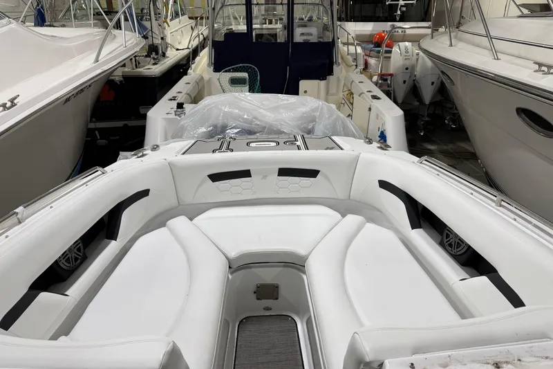 Slide: The Image of 2024 Four Winns HD5 boat interior with white seating in a showroom. - 10