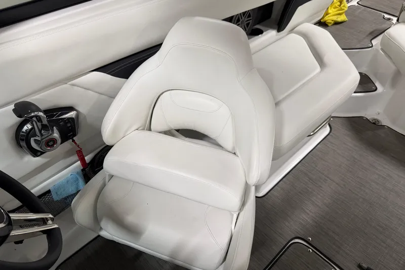 Slide: The Image of 2024 Four Winns HD5 boat interior with white captain's seat and control panel. - 18