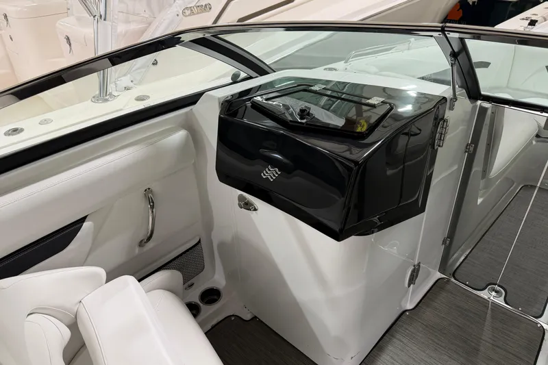 Slide: The Image of 2024 Four Winns HD5 boat interior with sleek black console and white seating. - 25