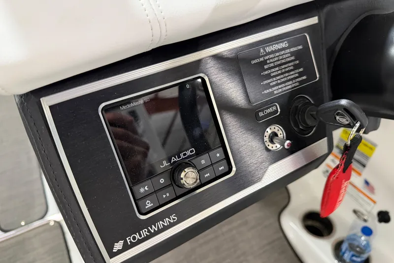 Slide: The Image of 2024 Four Winns HD5 boat dashboard featuring JL Audio system and ignition key. - 50