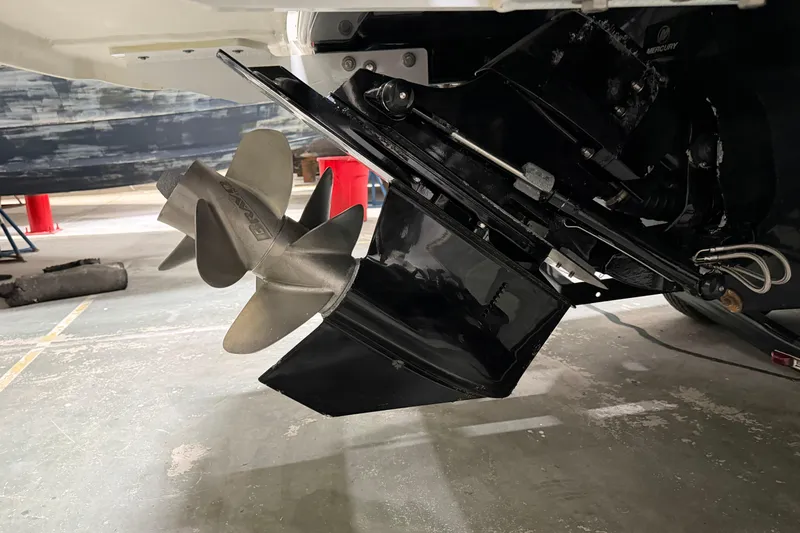 Slide: The Image of 2024 Four Winns HD5 boat propeller and outdrive in a garage setting. - 57