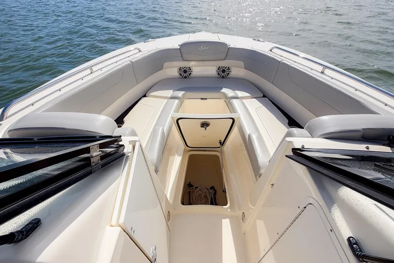Slide: The Image of 2023 Scout 277 Dorado boat interior with open storage compartment on calm water. - 12