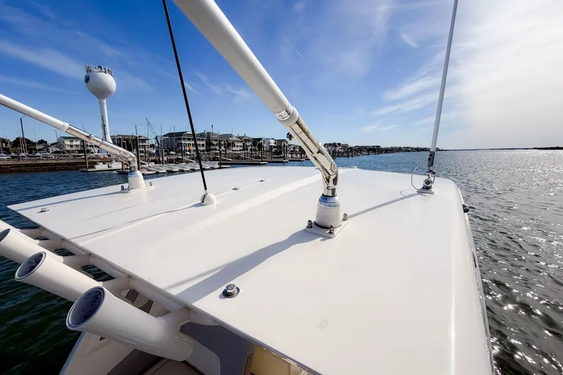 Slide: The Image of 2023 Scout 277 Dorado boat on water near marina, clear sky, and waterfront view. - 22