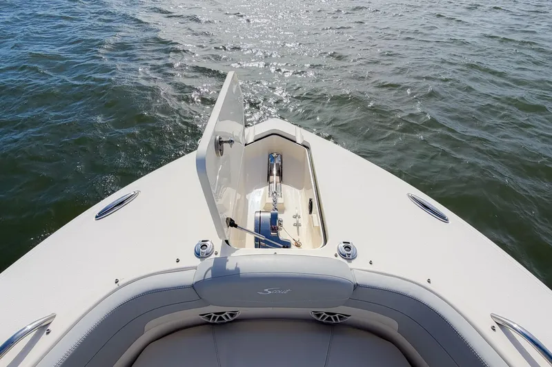 Slide: The Image of 2023 Scout 277 Dorado boat bow with open storage compartment on water. - 24