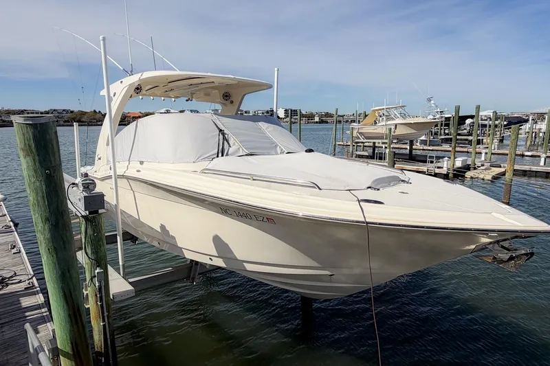 Slide: The Image of 2023 Scout 277 Dorado boat docked at marina, covered and elevated above water. - 25