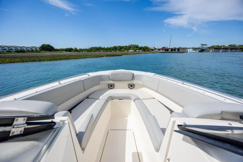 Slide: The Image of 2023 Scout 277 Dorado boat on calm water, showcasing spacious seating and scenic view. - 28