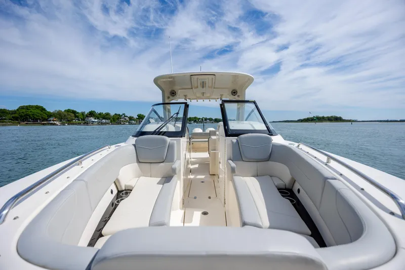 Slide: The Image of 2023 Scout 277 Dorado boat interior with luxurious seating on a calm water backdrop. - 30