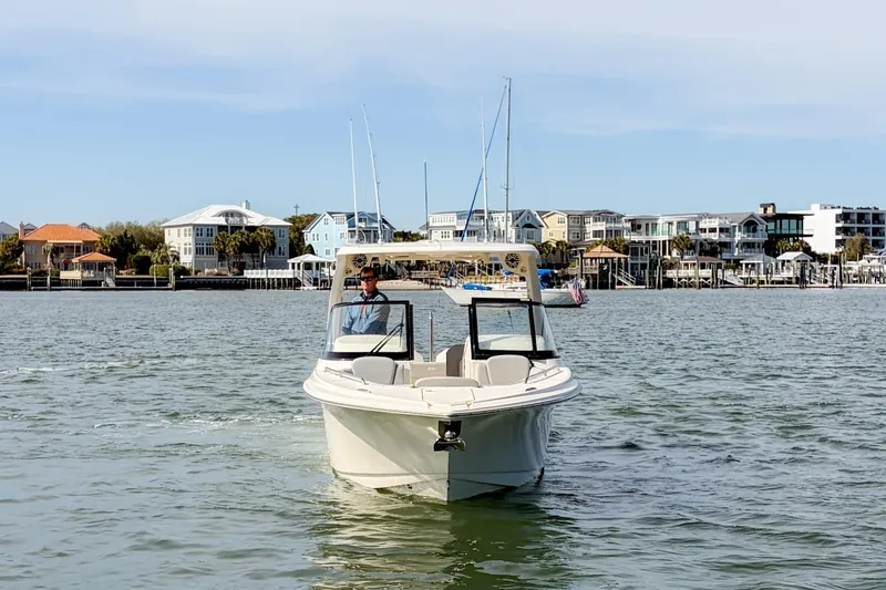 Slide: The Image of 2023 Scout 277 Dorado boat cruising near waterfront homes. - 7