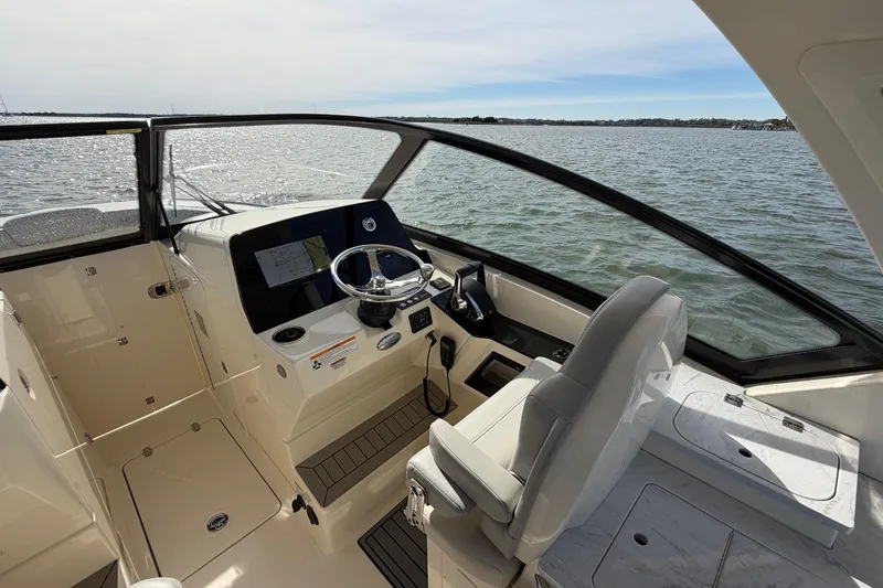 Slide: The Image of 2023 Scout 277 Dorado boat interior with steering wheel and dashboard on open water. - 9