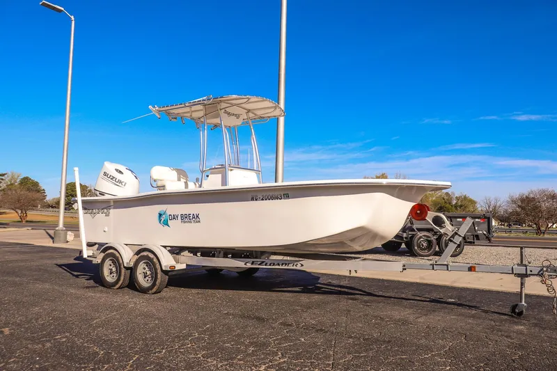 The Image of 2022 Savannah SS21 boat on trailer, featuring Suzuki engine, parked outdoors. - 0