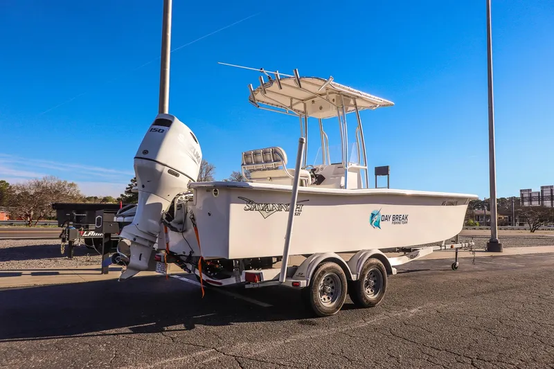 Slide: The Image of 2022 Savannah SS21 boat on trailer, parked outdoors under clear blue sky. - 2