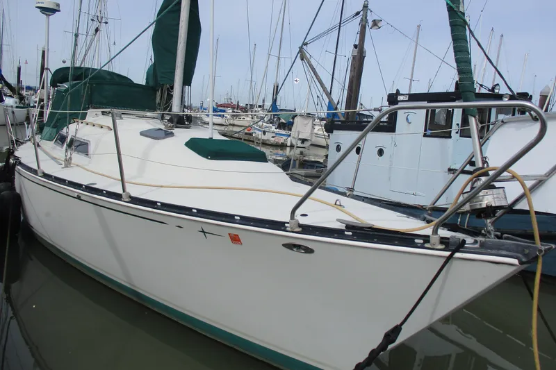 Slide: The Image of 1981 C & C 32 sailboat docked in a marina, featuring green sail covers. - 1