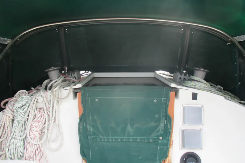 Slide: The Image of Interior view of a 1981 C & C 32 sailboat cockpit with ropes and green cover. - 13