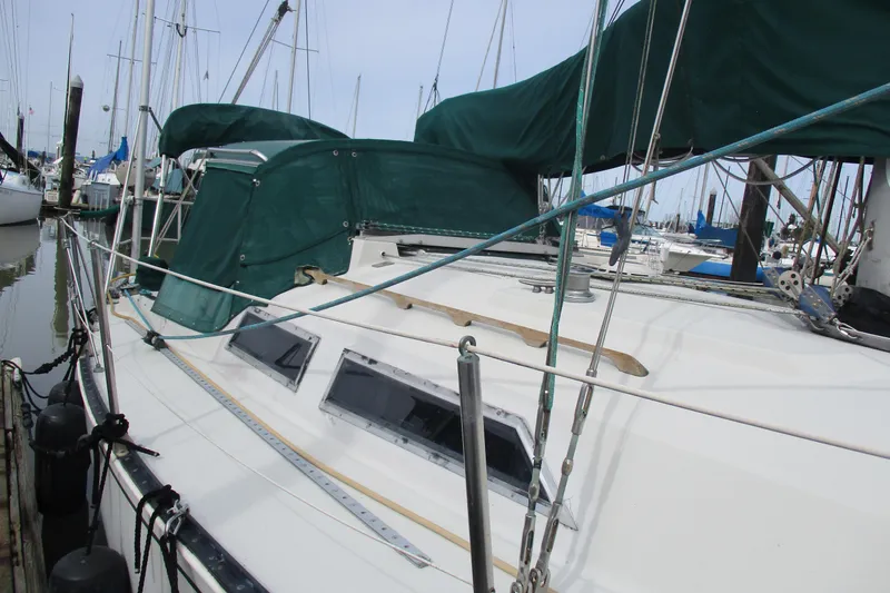 Slide: The Image of 1981 C & C 32 sailboat docked, featuring green covers and rigging. - 2