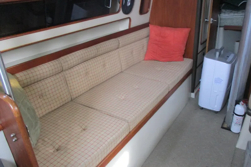 Slide: The Image of Interior of 1981 C & C 32 sailboat with cushioned seating and red pillow. - 33