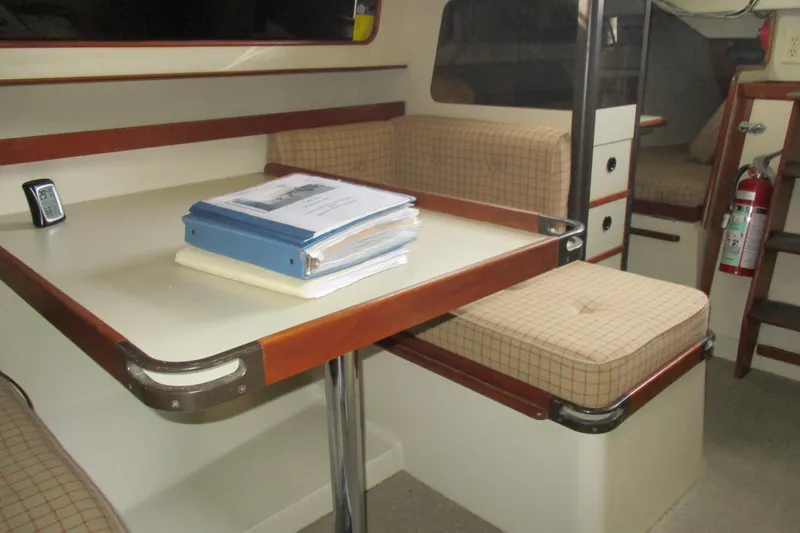 Slide: The Image of Interior of 1981 C & C 32 sailboat with dining area and checkered seating. - 41