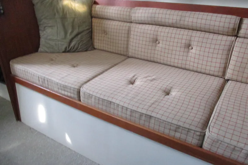 Slide: The Image of Cushioned seating area inside a 1981 C & C 32 sailboat, featuring plaid upholstery. - 42