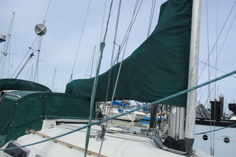 Slide: The Image of 1981 C & C 32 sailboat with green sail cover docked at marina. - 5