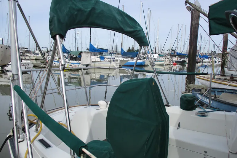 Slide: The Image of 1981 C & C 32 sailboat docked in marina with green covers. - 8