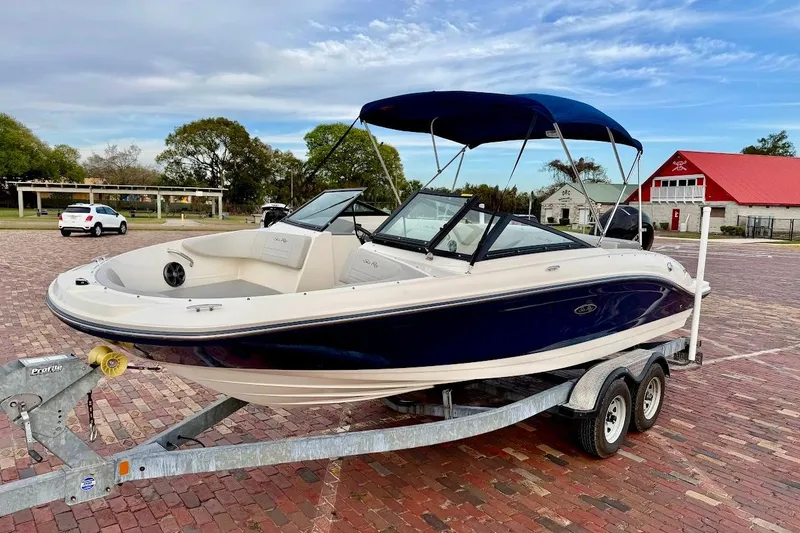 The Image of 2020 Sea Ray SPX 210 Outboard boat on trailer, parked on brick pavement. - 1