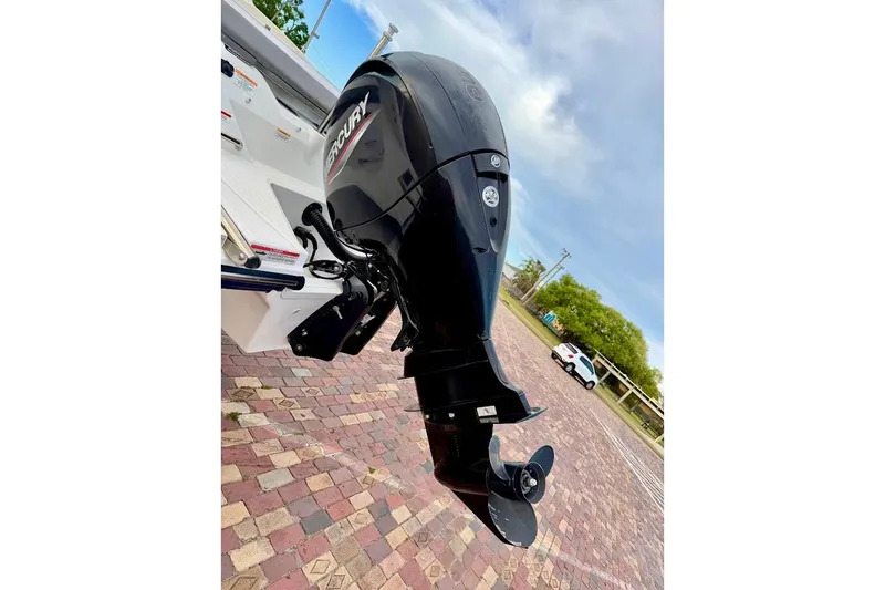 Slide: The Image of 2020 Sea Ray SPX 210 Outboard motor on brick pavement, under a cloudy sky. - 12