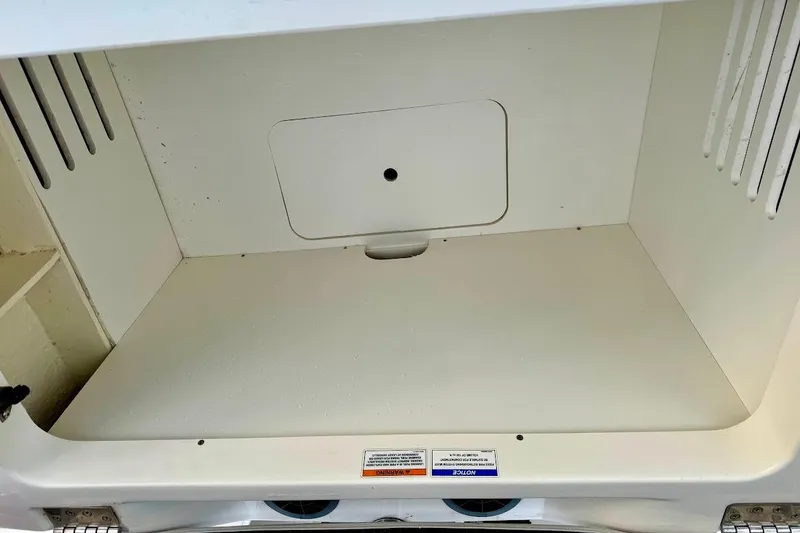 Slide: The Image of Storage compartment of a 2020 Sea Ray SPX 210 Outboard boat, featuring a clean interior. - 19